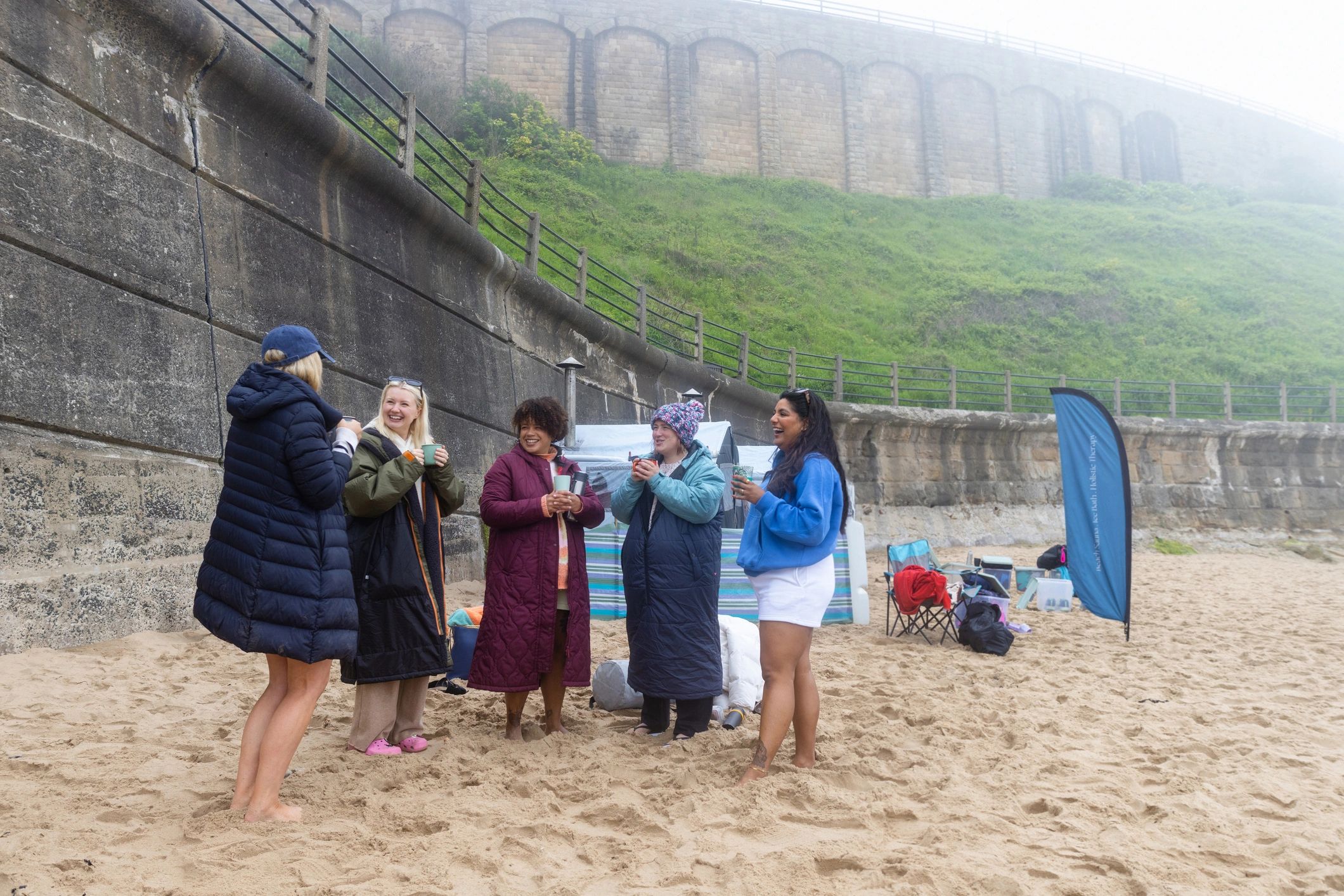 Group gathered on a beach near the water