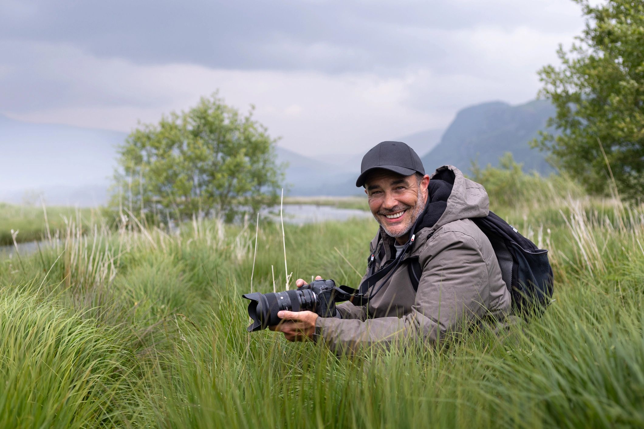 Portrait of a photographer holding a camera outdoors